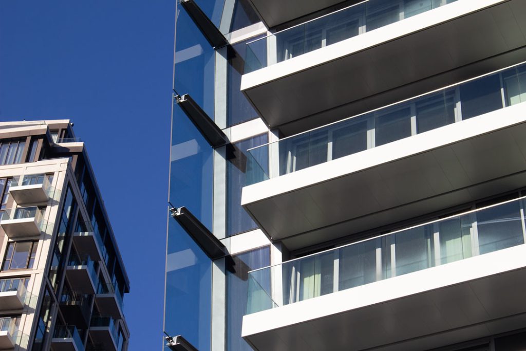 Cashmere Wharf: close-up of white balcony slabs with glass balustrades against a blue sky