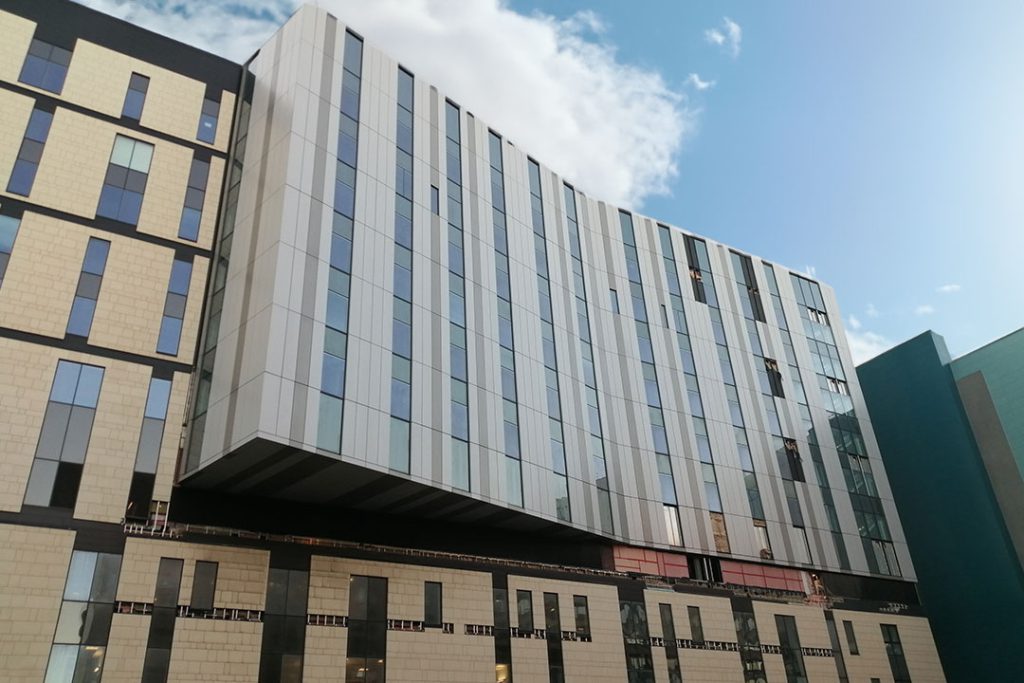 Royal Liverpool University Hospital: grey-clad upper floors cantilevered over a stone-faced base