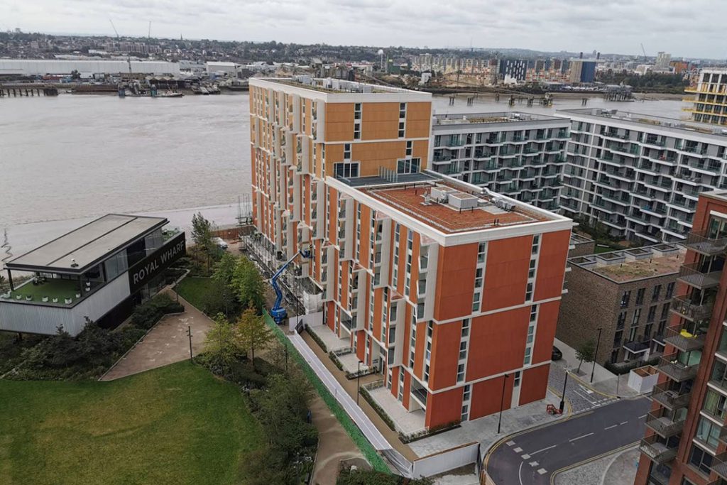 Aerial view of Royal Wharf apartment blocks beside the River Thames, with a pavilion signed 'Royal Wharf'